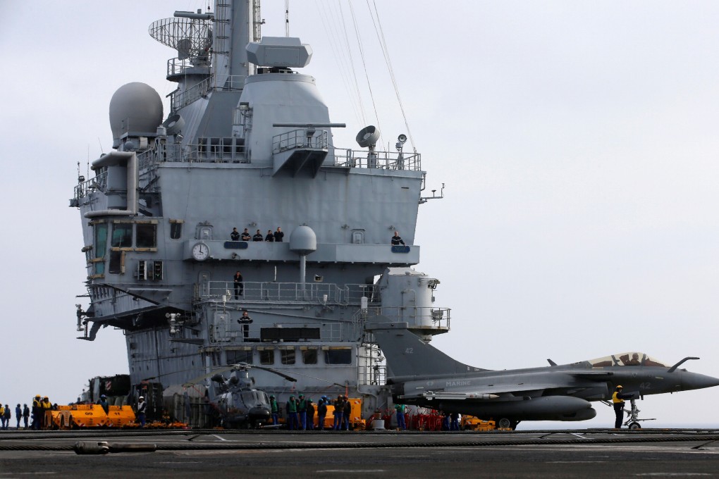 Flight deck crew members direct a French Rafale fighter jet on the French aircraft carrier Charles de Gaulle in the Mediterranean sea. Photo: reuters