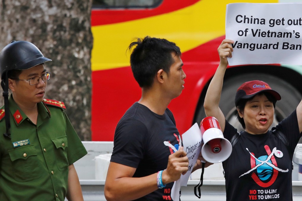 A Vietnamese policeman approaches anti-China protesters during a 2019 demonstration in front of the Chinese embassy in Hanoi, Vietnam. Photo: Reuters