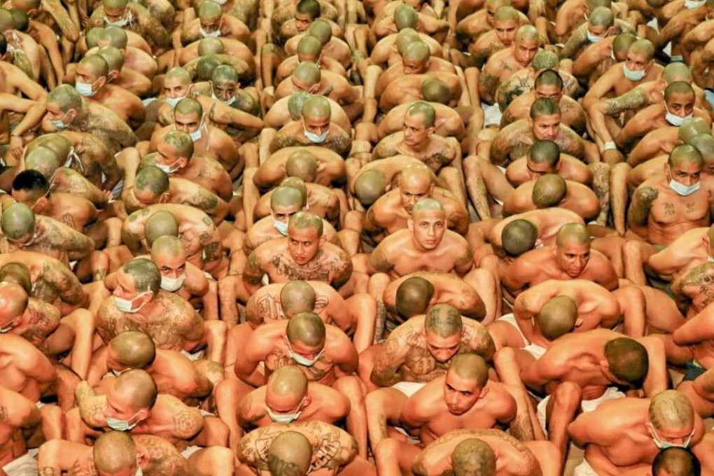 Hundreds of inmates in a detention centre – all dressed only in underpants and few wearing face masks – sitting in rows so close together their faces and backs touch. Photo: Reuters