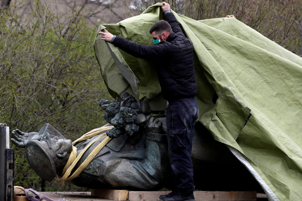 A worker covers the statue of Soviet general Ivan Konev after it was removed from its platform in Prague. Photo: Reuters