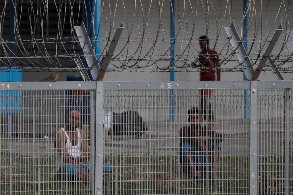 Migrant workers sit outside their rooms at a dormitory in Singapore during the coronavirus outbreak. Photo: Reuters