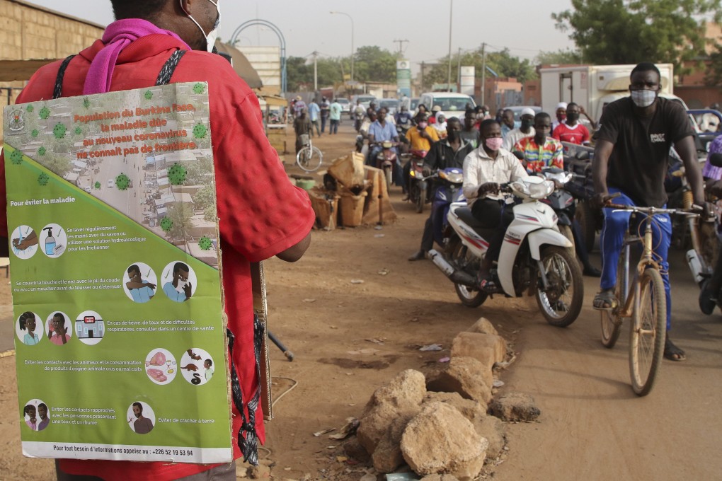 A man wears a poster promoting awareness of Covid-19, on the streets of Ouagadougou, Burkina Faso on March 30. Photo: EPA-EFE