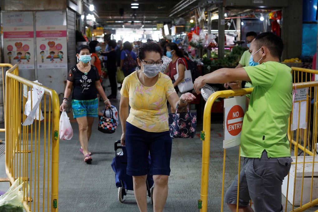 A woman has her hands sanitised while buying groceries amid the coronavirus outbreak in Singapore. Photo: Reuters