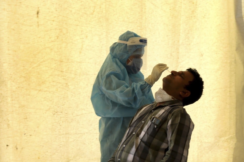 A health worker takes a swab test at a Covid-19 testing centre in New Delhi. India stopped using test kits from two Chinese firms over accuracy concerns. Photo: AP