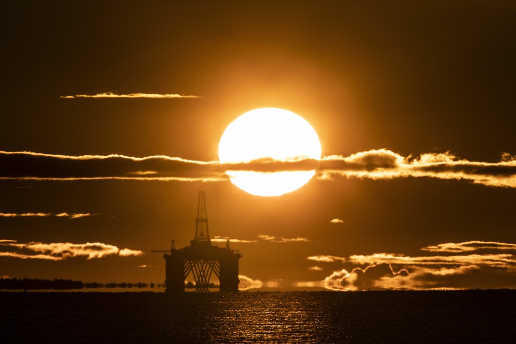 The sun rises behind an oil platform. Photo: PA Wire via dpa