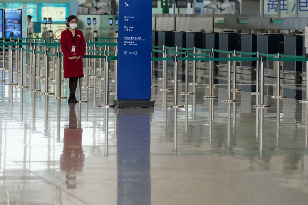 A Cathay Pacific employee stands near the check-in desks at a virtually deserted Hong Kong International Airport. Photo: Sam Tsang