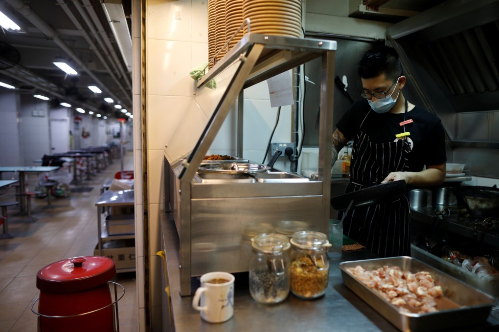 Hawker Jason Chua makes meals in his stall at Hong Lim Market & Food Centre in Singapore, one of few to remain open during the strict coronavirus circuit breaker measures. Photo: Reuters