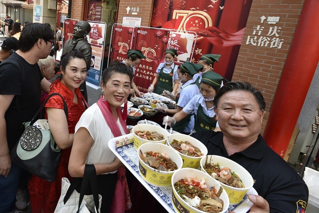 People enjoy bowls of Wuhan hot dry noodles outside a branch of Cailinji, the most famous hot dry noodles brand in the city, before the coronavirus struck. Photo: Cailinji