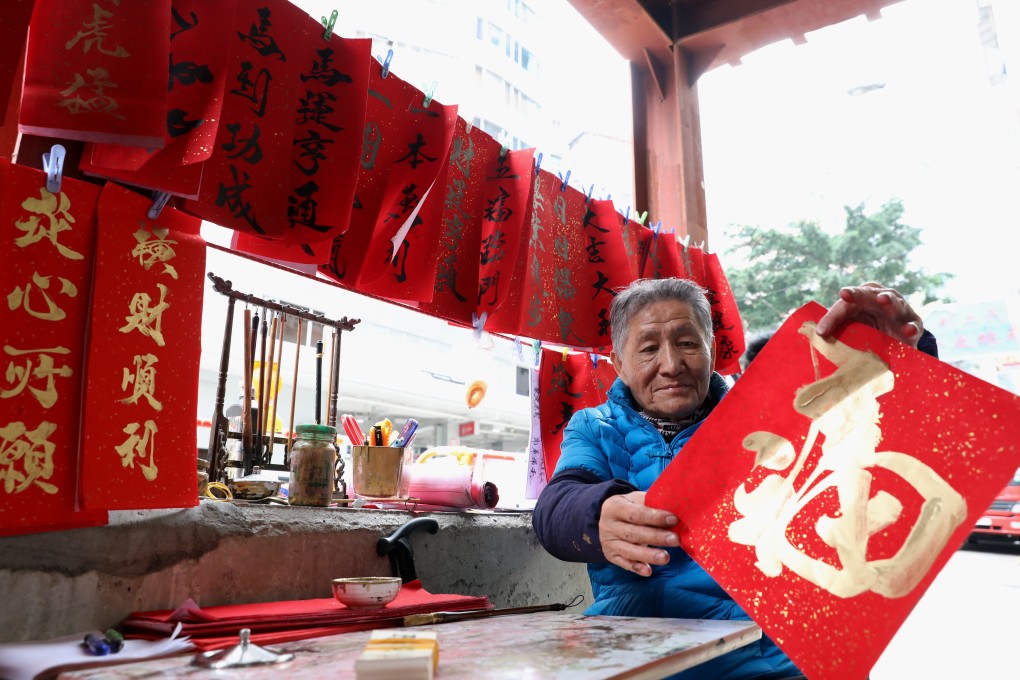 Street calligrapher Chan Kam-fat, 80, writes Chinese New Year greetings “fai chun” outside a construction site on Johnston Road in Wan Chai. Chan has been writing lucky red banners during Chinese New Year for ten years. 30JAN19 SCMP / Nora Tam