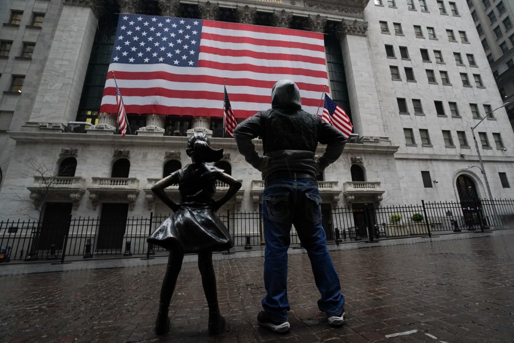 A man stands with the Fearless Girl statue across from the New York Stock Exchange on Wednesday. Photo: dpa