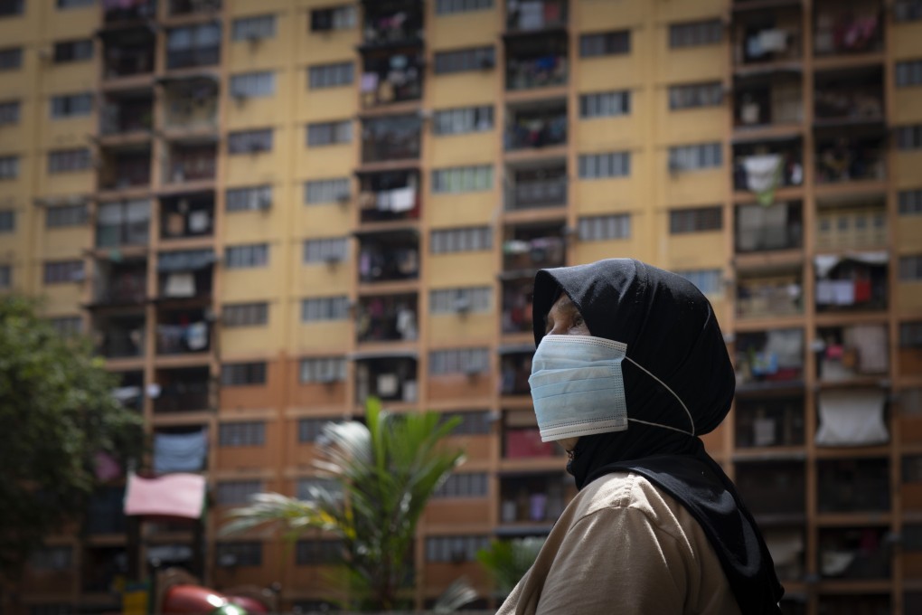 A woman walks near government apartments in downtown Kuala Lumpur, Malaysia, on April 30. Photo: AP