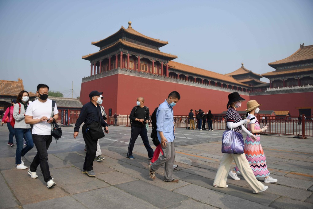 People wear face masks amid concerns of the coronavirus as they walk to the entrance of the Forbidden City in Beijing. Photo: AFP