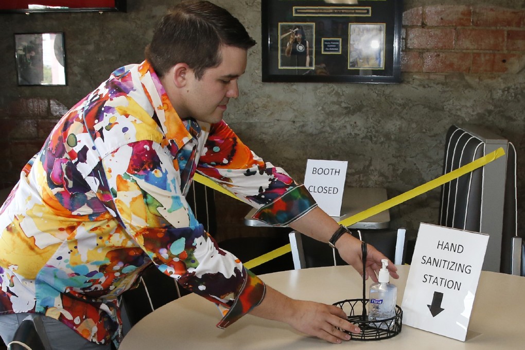 JP Wilson, owner of Falcone's Pizzeria in Oklahoma City, sets out hand sanitiser on a table at his restaurant on Thursday as he prepares to open the dining room to customers. Photo: AP