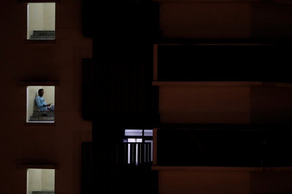 A migrant worker sits outside his room in a dormitory, declared as an isolation area, amid the Covid-19 outbreak in Singapore. Photo: Reuters