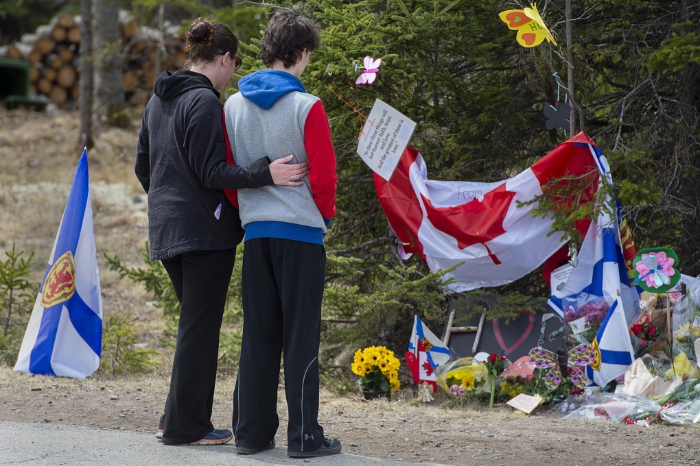 Visitors pay their respects at a roadside memorial for victims of a mass shooting in Portapique, Nova Scotia, in April. Photo: The Canadian Press via AP