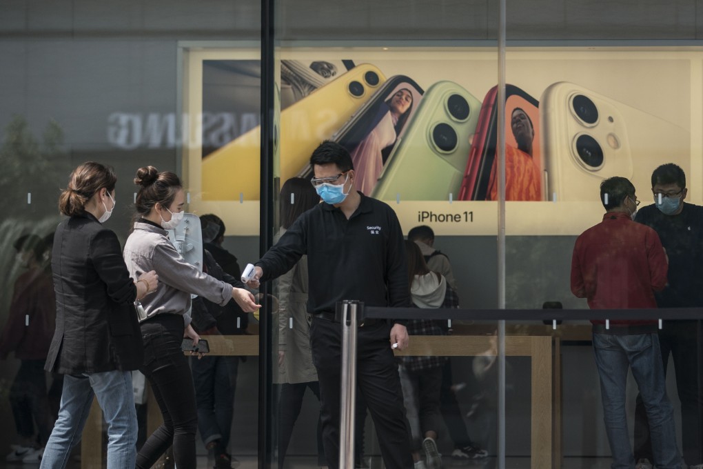 An employee wearing a mask checks the temperatures of customers outside an Apple store in Shanghai. In the event that the US continues to press forward with extensive decoupling, the likelihood is that it will inflict more harm on itself, its manufacturers and its own consumers than anyone else. Photo: Bloomberg