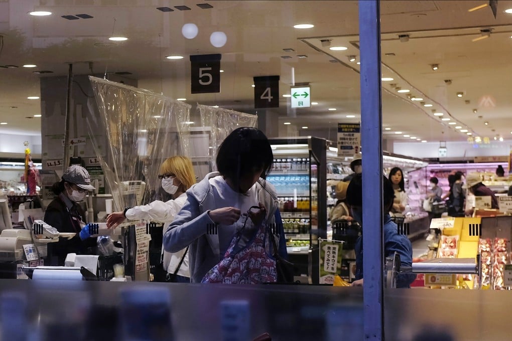 A woman bags her own groceries after checking out at a supermarket in Tokyo. Photo: AP Photo