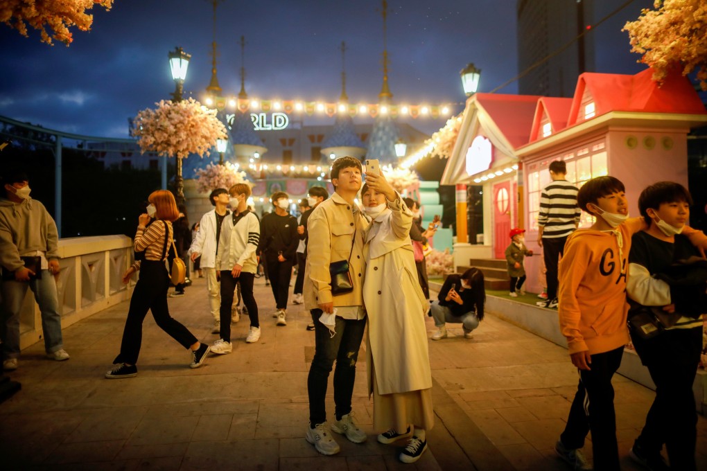 A couple remove their face masks to take a picture at an amusement park in Seoul on Thursday. Photo: Reuters