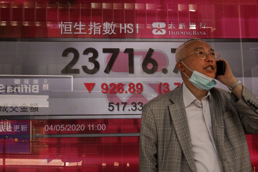 A man talks on his phone at a bank electronic board showing the Hong Kong share index at Hong Kong Stock Exchange on May 4, 2020. Photo: Associated Press