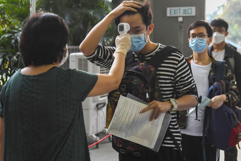 A school pupil has his temperature checked as he enters an exam hall for the Diploma of Secondary Education. Photo: Handout