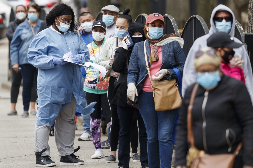 A health care worker talks with people waiting in line at a newly opened Covid-19 community testing location in New York on Monday. Photo: EPA-EFE