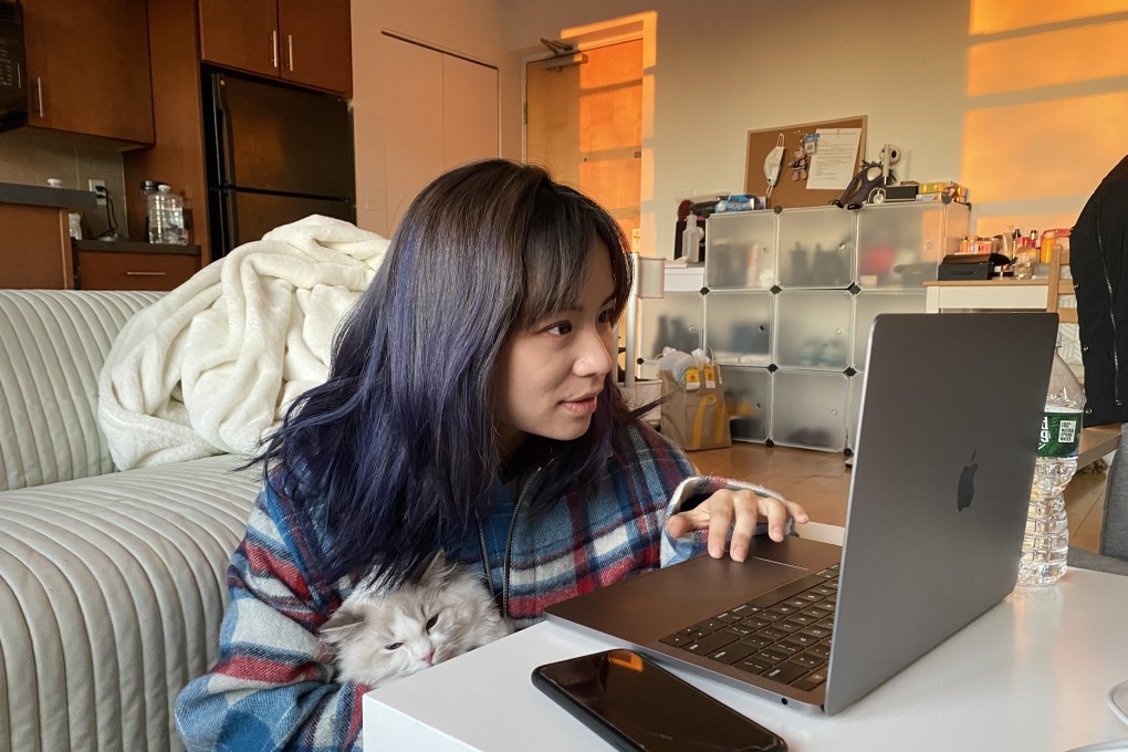 A Chinese student at Boston University works online while cuddling her cat at her home in Boston, Massachusetts, on March 27. While some feel online education is inadequate because of the decreased human interaction, other students find themselves more comfortable interacting with their teachers and peers through screens. Photo: Xinhua