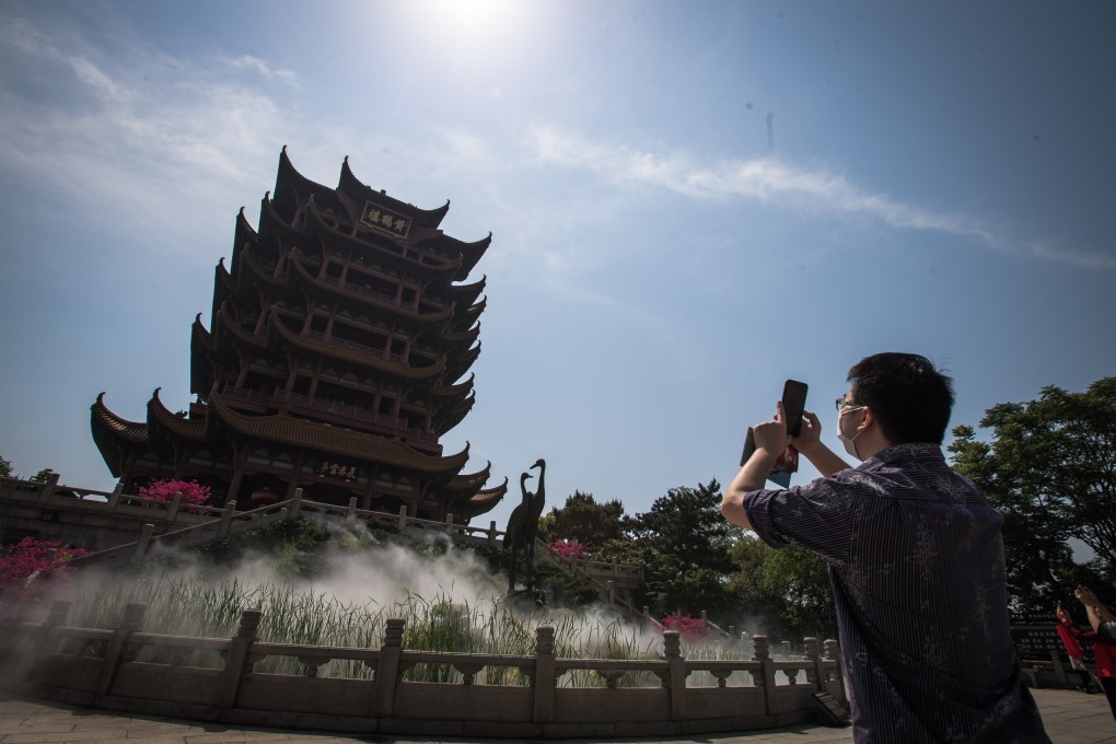A tourist photographs the Yellow Crane Tower, one of the most popular tourist attractions in Wuhan, in central China’s Hubei Province, on April 29. Photo: Xinhua