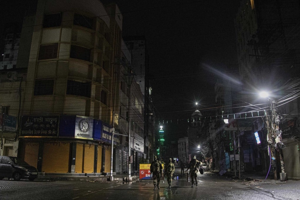 Indian paramilitary personnel patrol a deserted street during a lockdown in Gauhati. Photo: AP