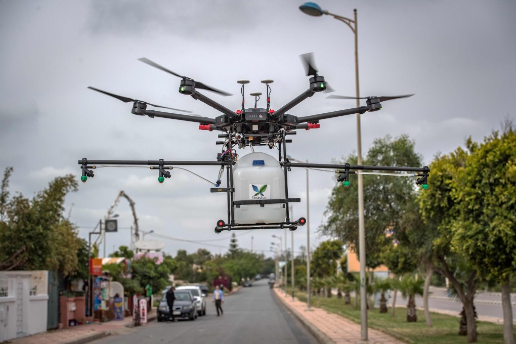 A DJI drone equipped with disinfectant liquid flies above a street of Harhoura, a city near the capital Rabat, on April 23 amid efforts by Morocco to contain the spread of the novel coronavirus. Photo: Agence France-Presse