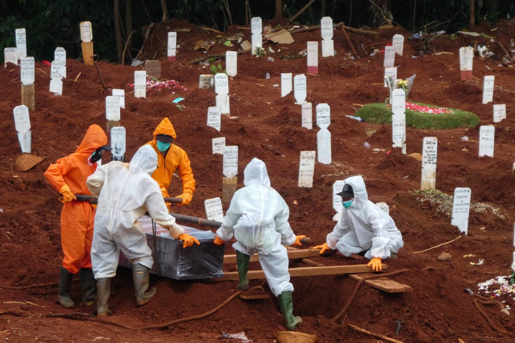 Workers move the coffin of a coronavirus victim at a cemetery in Jakarta. Photo: AFP
