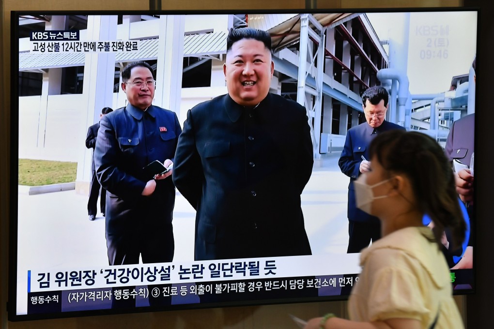 A woman wearing a face mask walks past a television news screen showing a picture of North Korean leader Kim Jong-un. South Korean officials believe he reduced his public activities because of Covid-19 fears. Photo: AFP