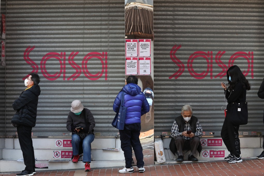 The queue of people, waiting in line for the opening of a pharmacy to buy surgical masks outside a shuttered Sasa outlet at Jardine's Bazaar in Hong Kong. Photo: Nora Tam