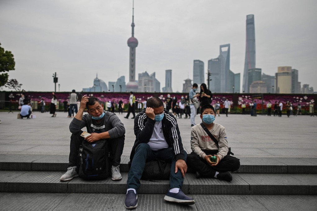 Men wearing face masks take a rest while visiting the promenade on the Bund along the Huangpu River in Shanghai during the May Day holiday. With optimism and a heavy dose of caution, millions of Chinese hit the road or visited newly reopened tourist sites during the national holiday. Photo: AFP
