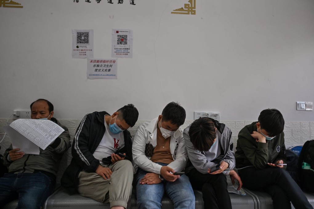 Men wait in an employment agency for a car to take them to their new jobs, in Shanghai on April 28. Photo: AFP