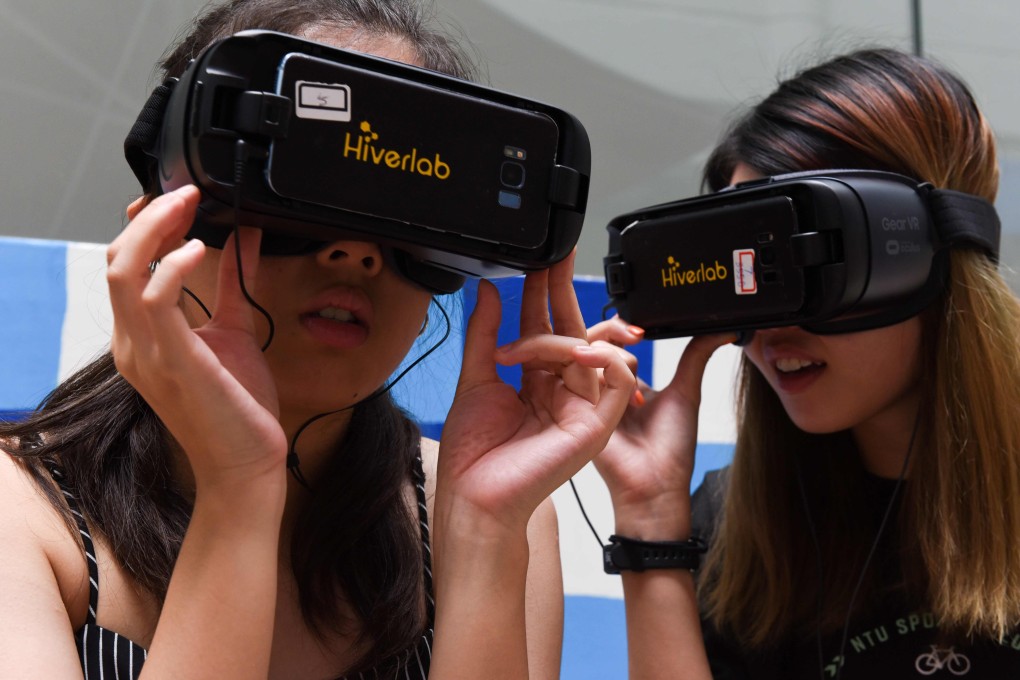 Students Tan Tong and Chin Hui Shan watching virtual reality simulations of men making lewd comments. Photo: AFP