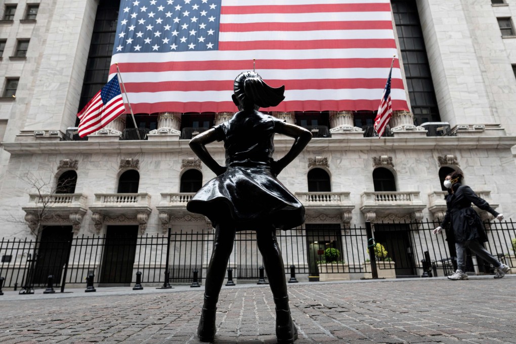 People walk past The Fearless Girl statue outside the New York Stock Exchange on April 20. The S&P 500 is down 12 per cent this year, compared to a 20 per cent drop in the the MSCI All Countries World ex US index. Photo: AFP