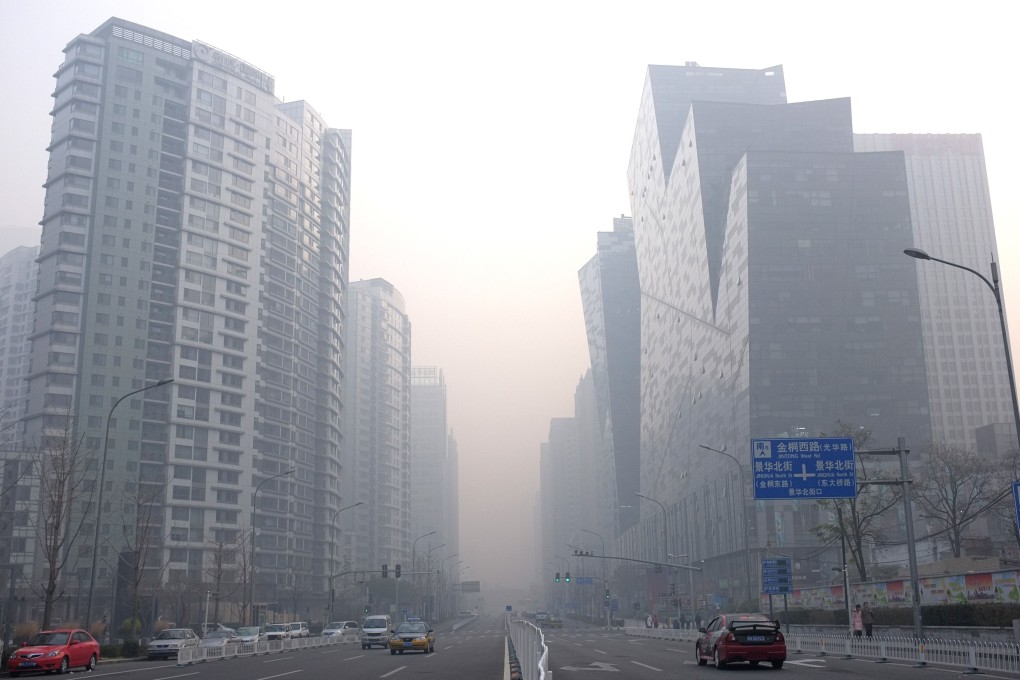 Cars drive along roads through high-rise buildings in the haze in the central business district in Beijing. Photo: AFP