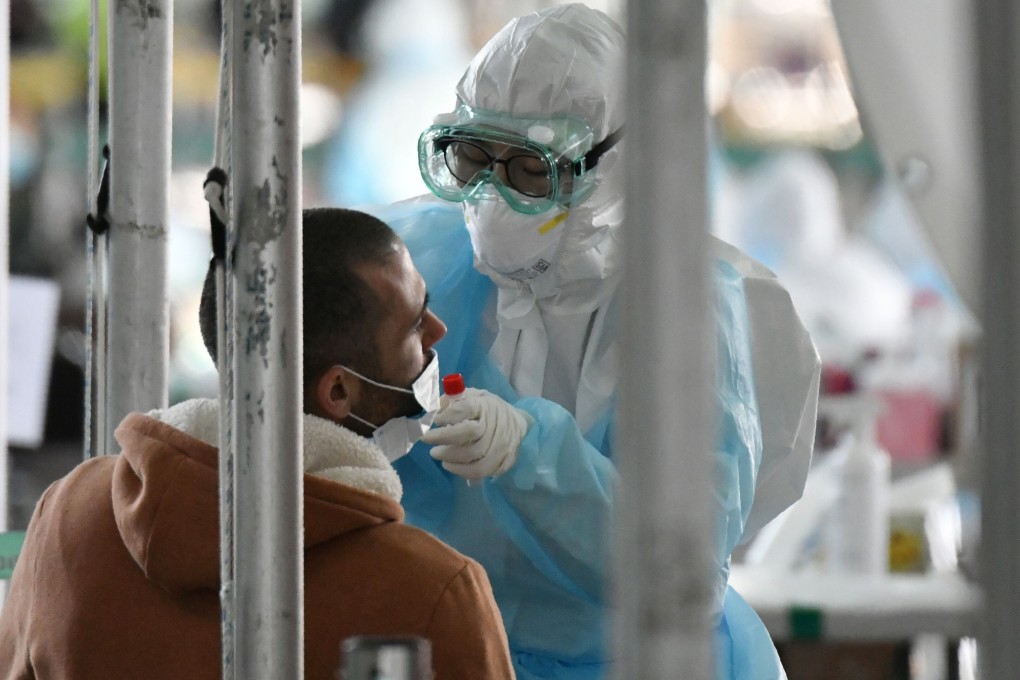 A medical worker, covered in protective clothing, takes coronavirus test samples. South Korean officials have concluded that those who test positive twice are most probably returning “false positive” results. Photo: AFP