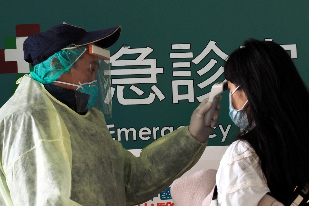 A staff member checks the temperature of a woman at the emergency department of a hospital in Taipei, Taiwan, on February 2. Taiwan and the WHO have engaged in a war of words over the latter’s handling of the Covid-19 crisis. Photo: EPA-EFE