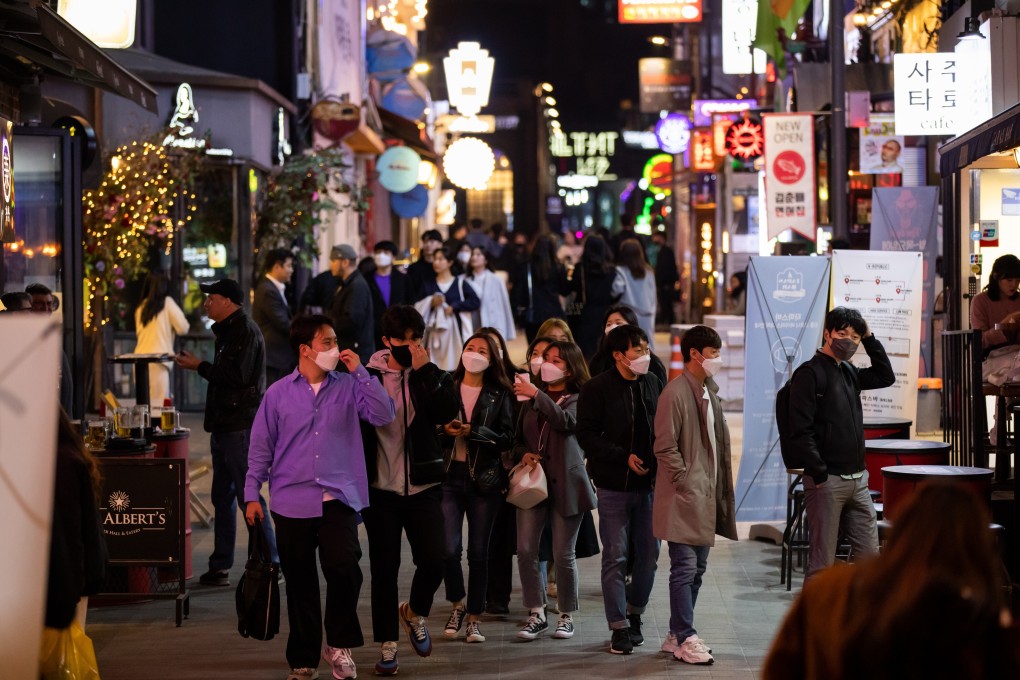 People wearing protective face masks walk through the Itaewon district in Seoul. South Korea reported a cluster of new cases linked to nightclubs in the popular area. Photo: Bloomberg