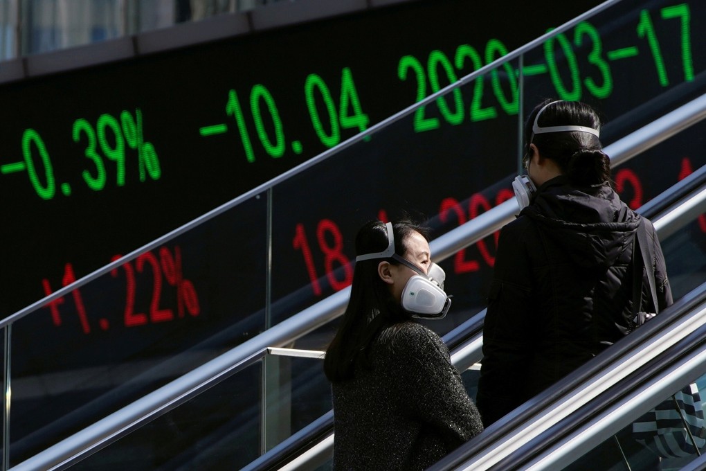 Pedestrians ride an escalator near an overpass with an electronic board showing stock information in Shanghai on March 17, 2020. Photo: Reuters