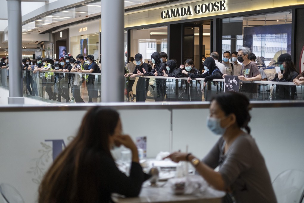 Diners enjoy lunch as protesters chant slogans in the IFC Mall. Photo: Bloomberg