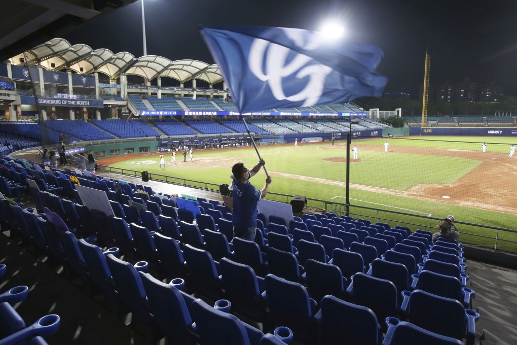 A cheerleader waves a flag in an otherwise empty seating section as a Chinese Professional Baseball League game is played in a stadium in New Taipei City with no spectators on April 24. Authorities will gradually allow fans back in to stadiums. Photo: AP