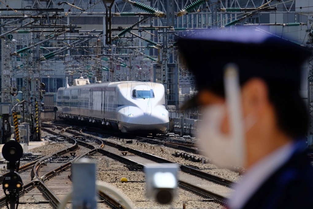A security guard wearing a face mask stands in front of a Shinkansen bullet train upon its arrival at Tokyo Station on April 25. Photo: AFP