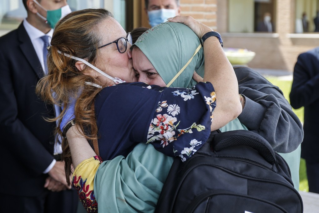Silvia Romano, wearing a green tunic, hugs her family upon her arrival in Rome on May 10, 2020. Photo: EPA-EFE/Handout
