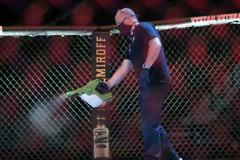 A worker sprays sanitiser in the octagon before UFC 249. Photo: AP