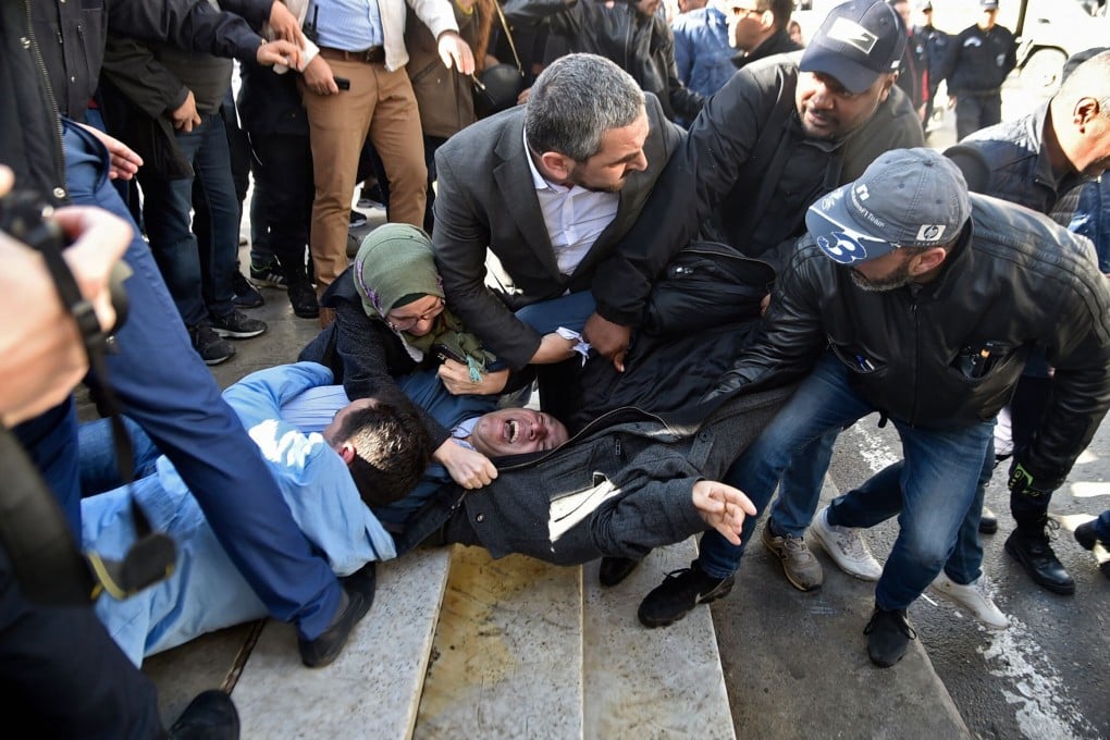 Samir Benlarbi (centre), an Algerian opposition figure of the “Hirak” movement, tries to stop plain clothes policemen from detaining a protester in Algiers in February 2019. Photo: AFP