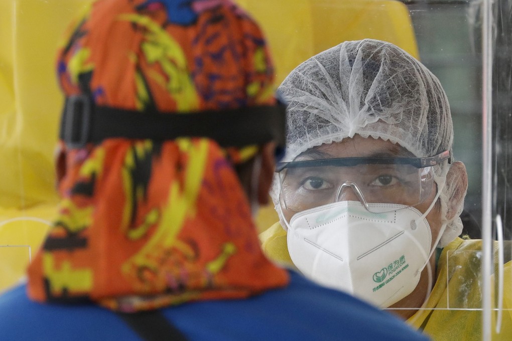 A Philippine health worker questions visitors during mass coronavirus testing. Photo: AP