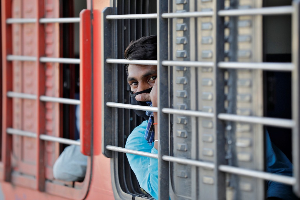 A migrant worker looks out from a train that will take him to his home state of Uttar Pradesh, in Ahmedabad, India. Photo: Reuters