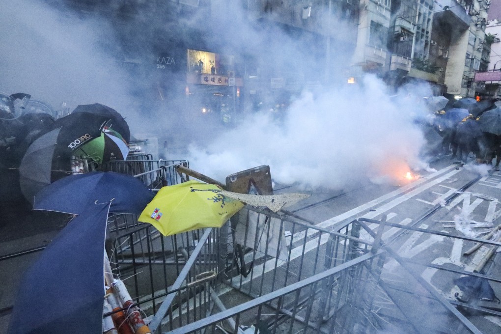 Riot police fire tear gas at anti-government protesters on Des Voeux Road West on July 28, 2019. Photo: Felix Wong